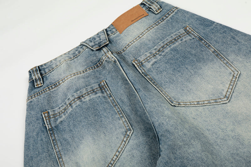 Close-up of the back waist on light wash jeans with tan label and back pockets