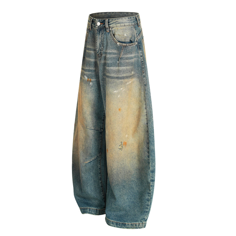 Angled front view of wide-leg jeans with faded blue denim, front pockets, and distressing