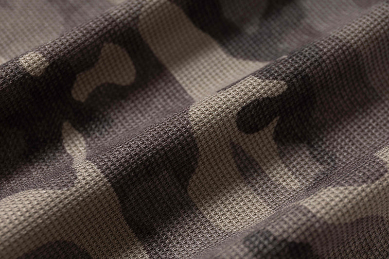 Close-up of textured brown and black camo fabric with a rugged woven finish for a streetwear hooded tee