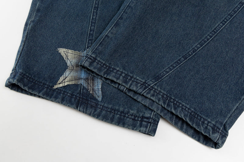 Close-up of jean hem with star patch and folded cuff detail