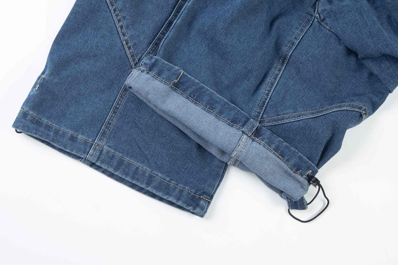 Close-up of blue denim cuff with drawstring hem and snap detail