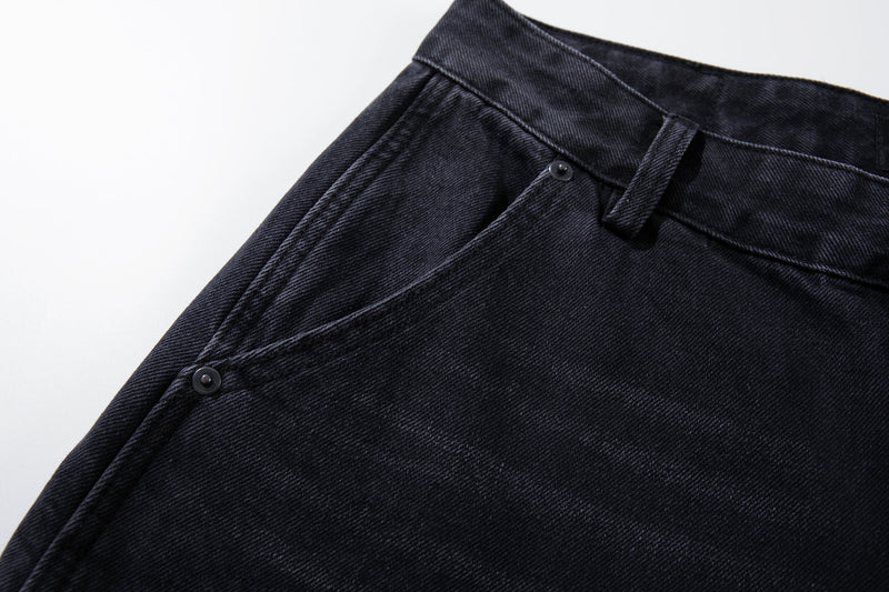 Close-up of the front waistband and belt loop on washed black jeans