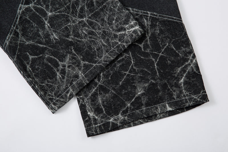 Close-up of hem on black cracked-pattern denim pants