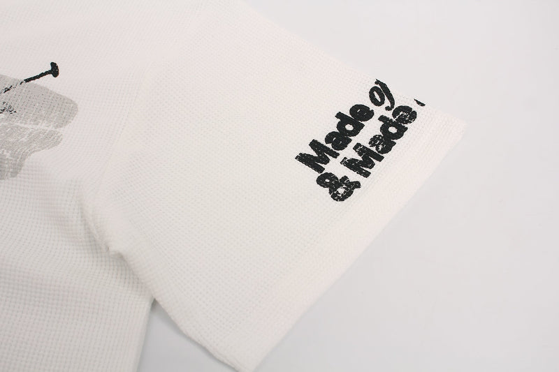 White distressed streetwear tee sleeve with black Made of Love graphic print on textured fabric