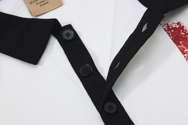 Close-up of a white men's polo shirt with black trim, black buttons, and red graphic print details