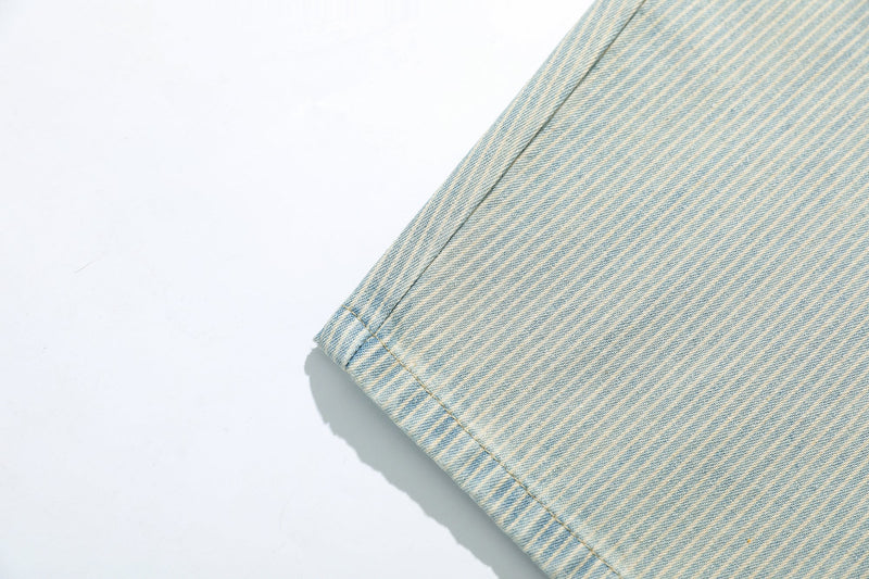 Close-up of the hem on light wash striped denim pants