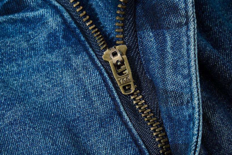 Close-up of metal zipper on blue washed camo denim
