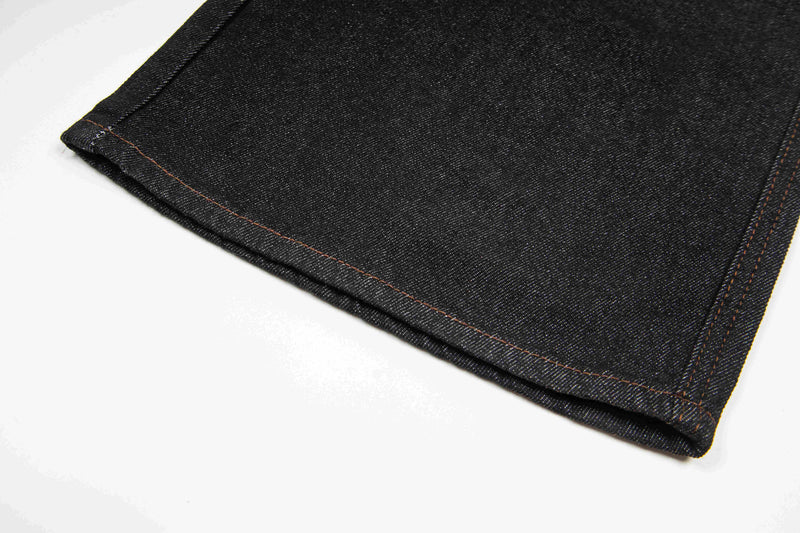 Close-up of hem on dark wash wide-leg denim pants with topstitching
