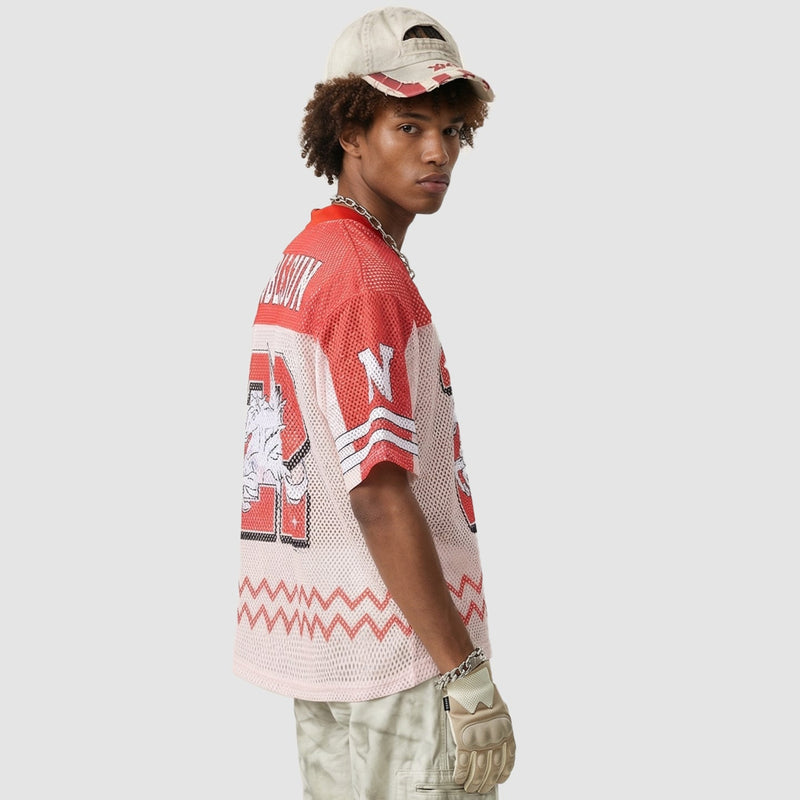 Model wearing a red and white mesh jersey T-shirt with streetwear graphics, beige cap, chain, and gloves