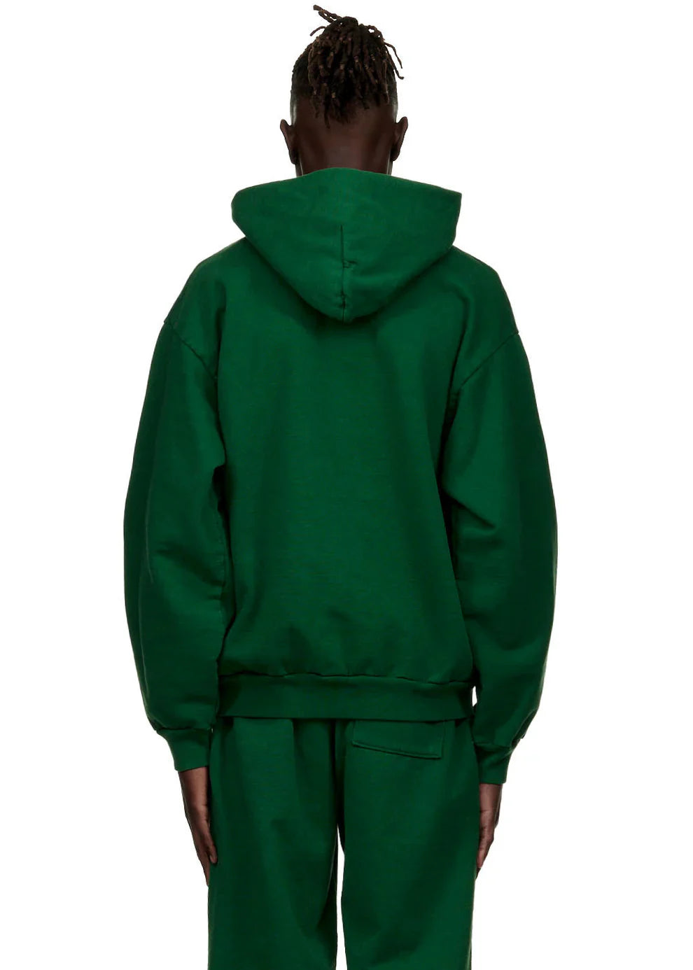 A person stands with their back to the camera, wearing the Dark Green Graphic Hoodie with Spider Web Print—its hood up. The comfort fit pullover is paired with matching pants for a casual, everyday streetwear look.