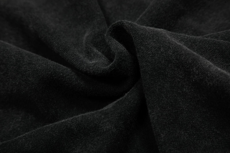 Close-up of black washed hoodie fabric with soft textured folds