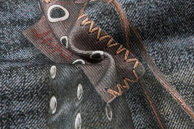 Close-up of printed denim with polka dots and stitched graphic text details