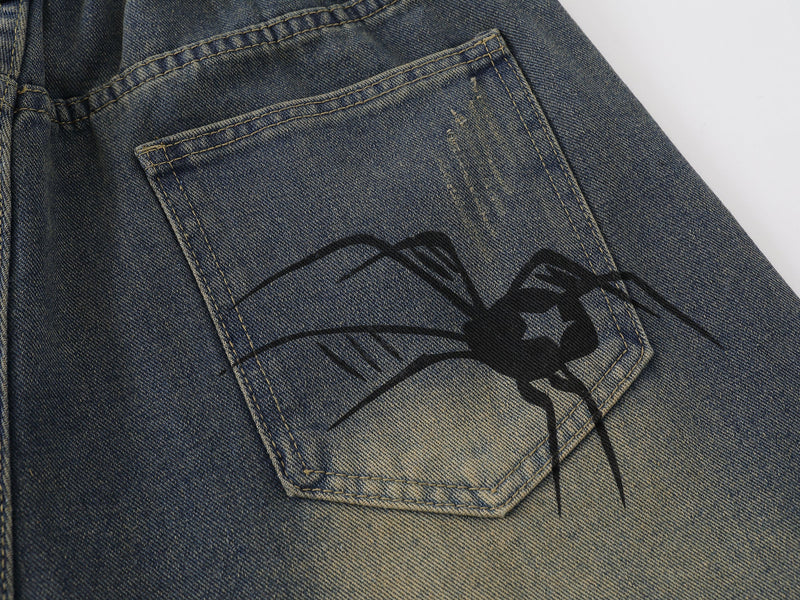 Close-up of back pocket on blue denim shorts with spider web graphic detail