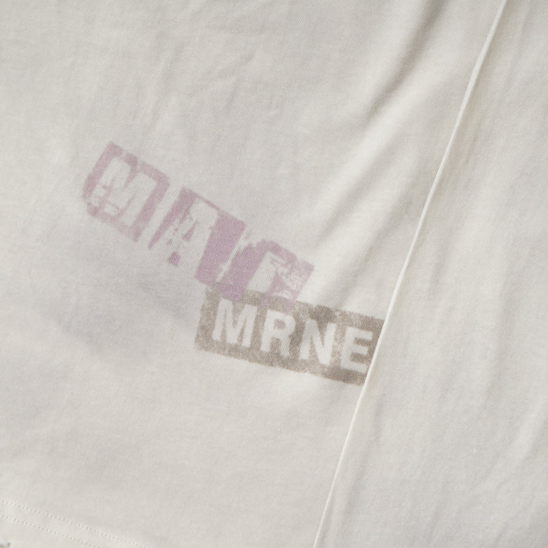 Close-up of small purple text and partial brown print on cream fabric