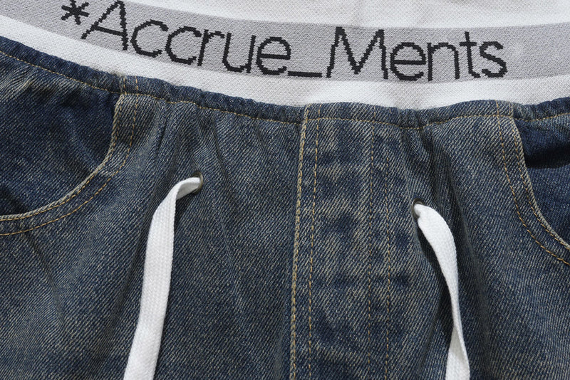 Close-up of denim waistband with white drawstrings and Accrue_Ments elastic band