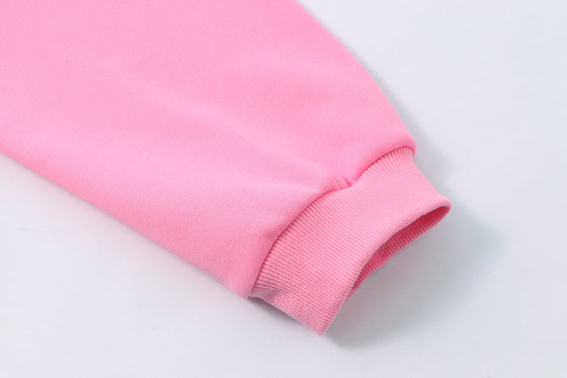 Pastel pink hoodie sleeve cuff close-up with ribbed knit hem