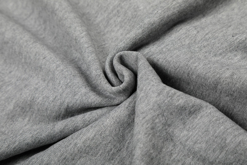 Close-up of soft heather gray fleece fabric with folded texture