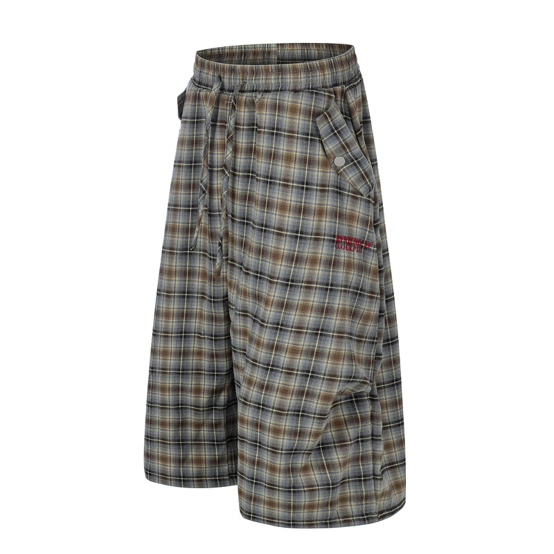 Three-quarter view of plaid lounge shorts with elastic waistband and snap cargo pocket detail
