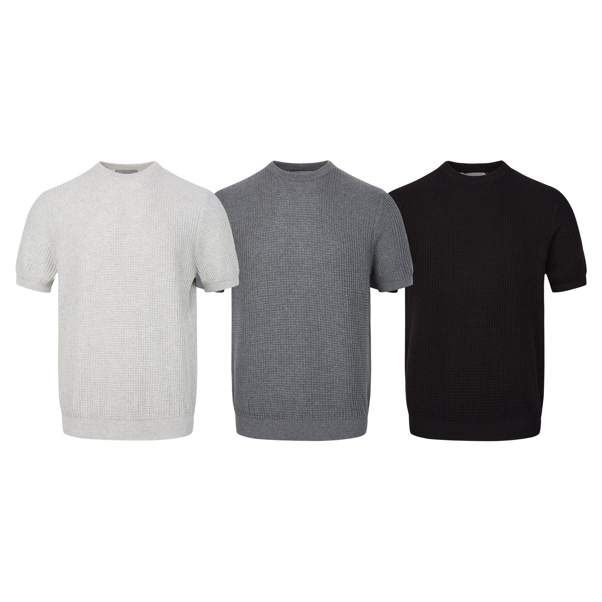 Three waffle knit short-sleeve sweaters in white, grey, and black displayed side by side on a white background