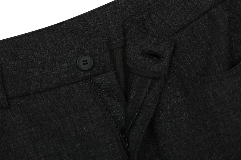 Close-up of black cargo pants waistband showing button, zipper fly, and front seam