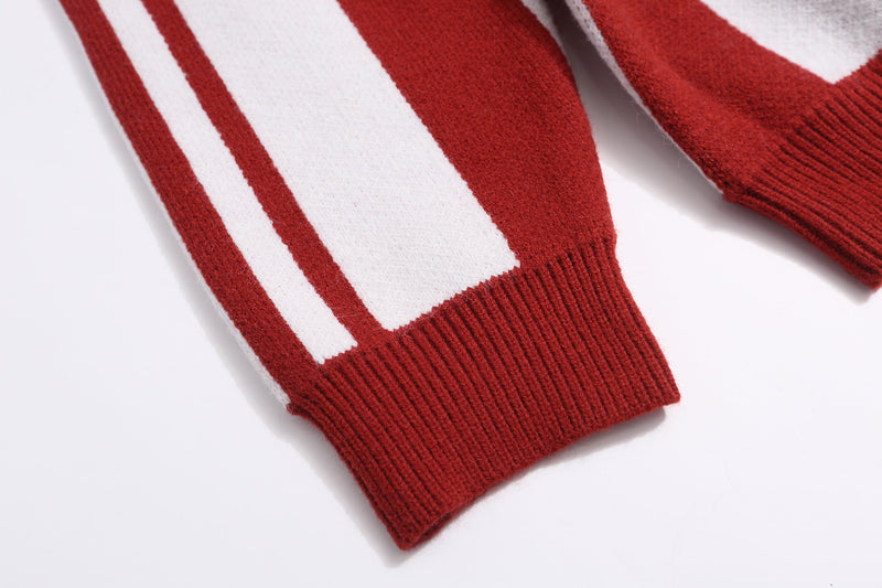 Close-up of ribbed red cuff and striped sleeve on knit sweater