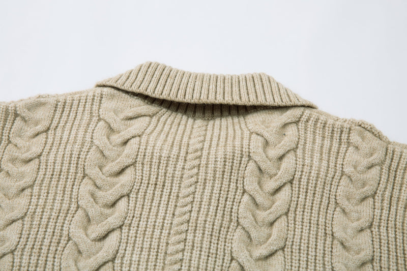Close-up of beige cable knit sweater jacket collar and upper chest