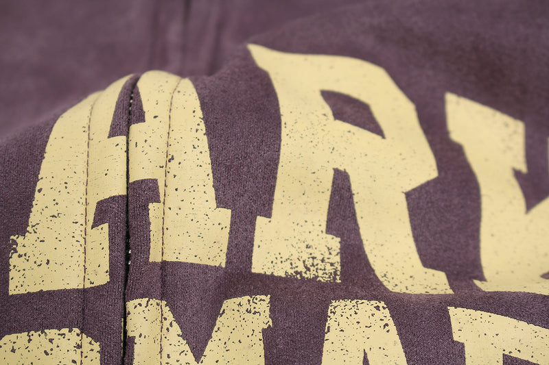 Close-up of the bold lettering across the chest on purple suede hoodie