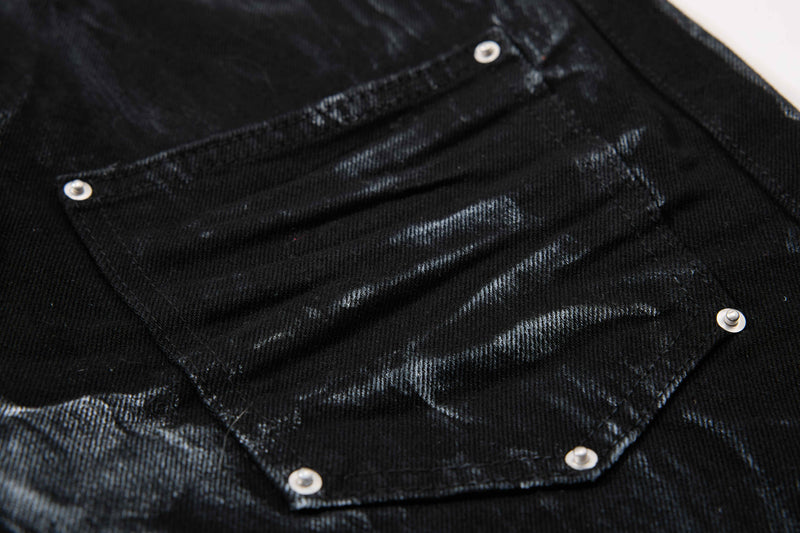 Close-up of black back flap pocket with rivets and faded denim texture