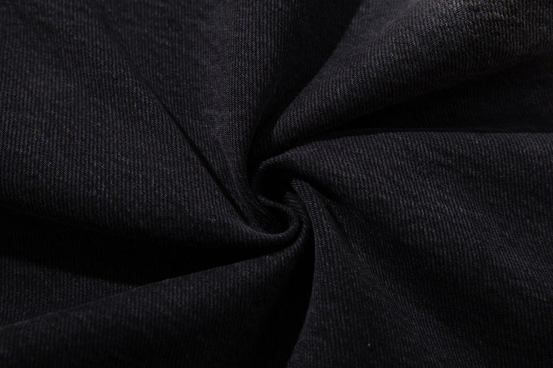 Close-up of dark wash denim fabric showing a soft folded texture