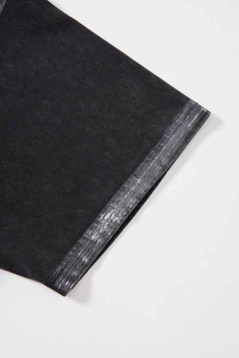 Close-up of a black washed T-shirt sleeve with distressed white cuff detail on a white background