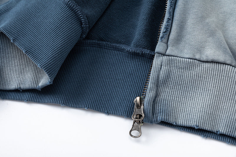 Close-up of zipper and ribbed hem on washed blue hoodie