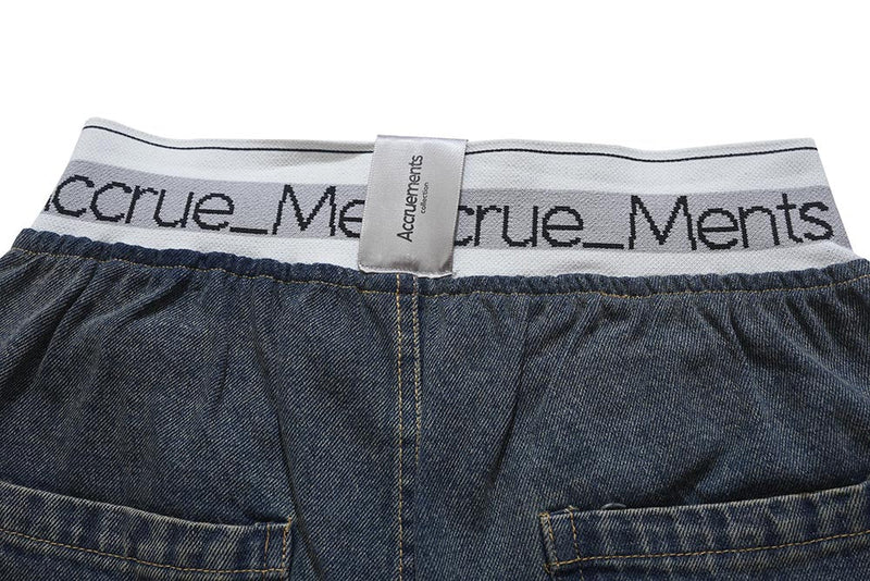 Close-up of back waistband and top seam on dark wash denim pants