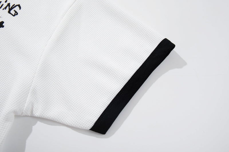 White textured graphic tee sleeve with black cuff detail and partial graffiti-style print