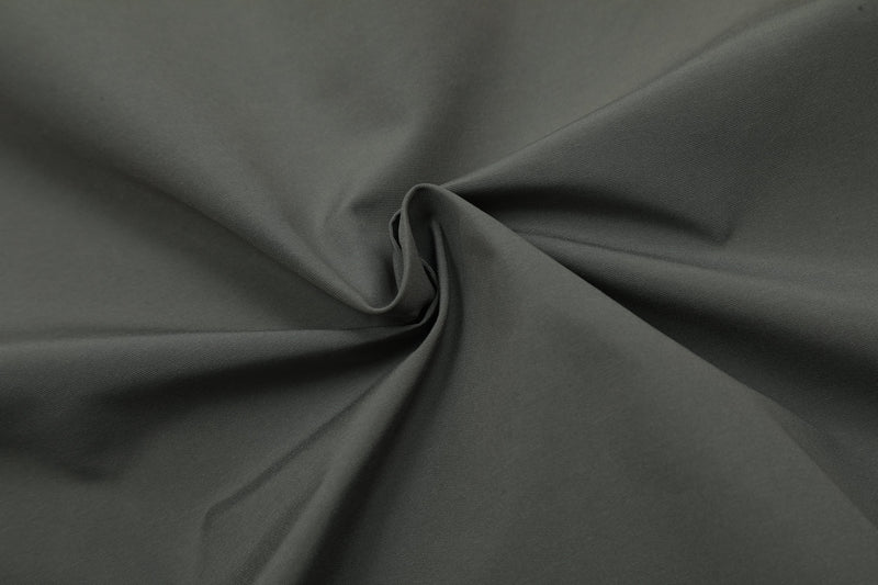 Close-up of dark gray windbreaker fabric with soft folded texture