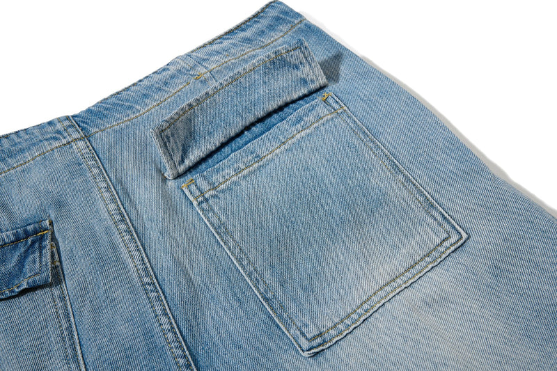 Close-up of square back pocket and waistband on light wash baggy jeans
