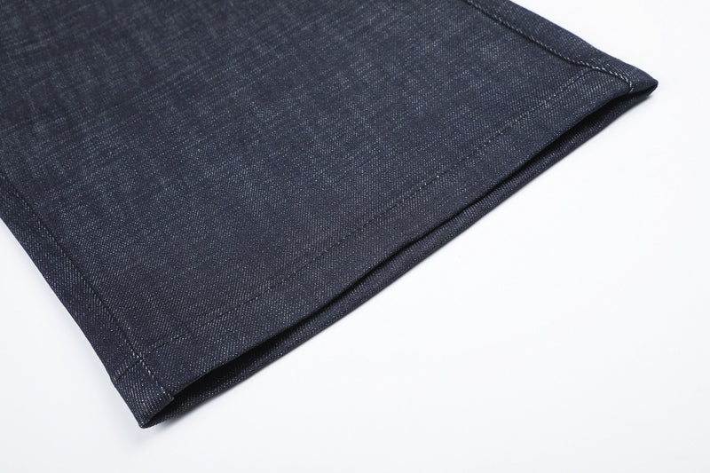 Close-up of dark denim leg hem and seam stitching