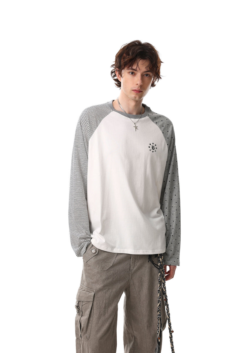 Model wearing white raglan long sleeve tee with mixed pattern sleeves and small chest graphic