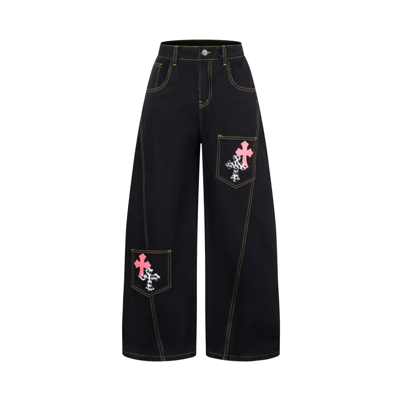Black wide-leg jeans with front pockets and pink, black, and white cross patches