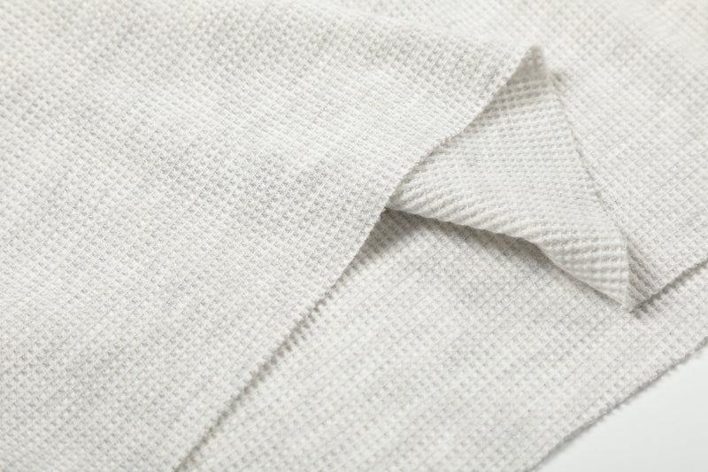 Close-up of light gray waffle knit fabric and seam detail