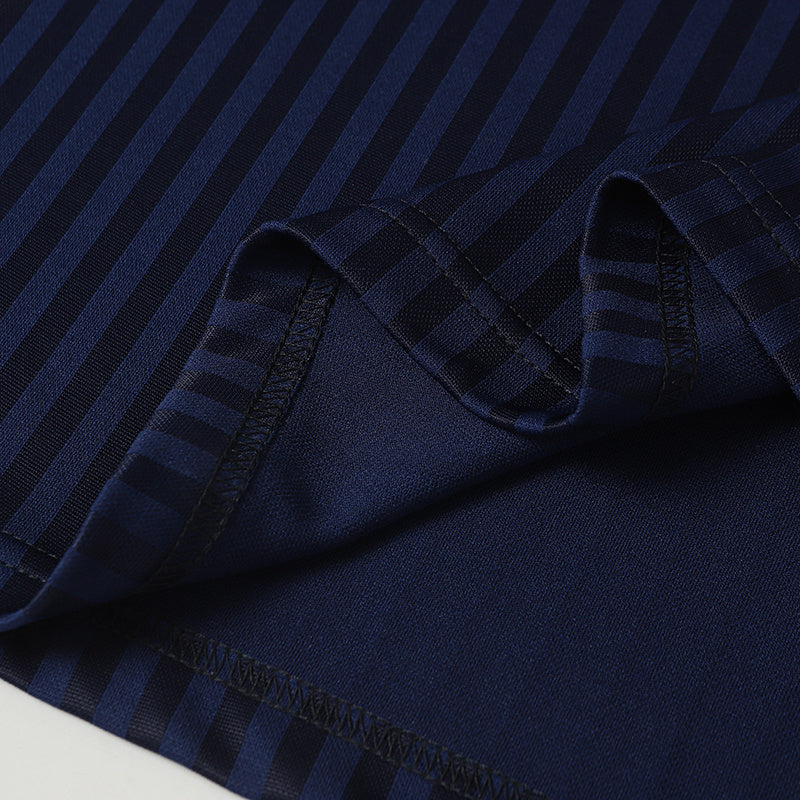 Close-up of a dark navy soccer jersey with diagonal stripes and stitched hem detail