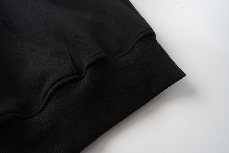Close-up of black ribbed cuff and sleeve hem on the hoodie