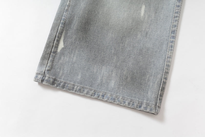Close-up of hem on light wash wide-leg jeans with faded edge stitching