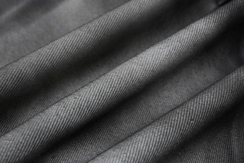 Close-up of gray denim fabric with visible diagonal twill weave texture