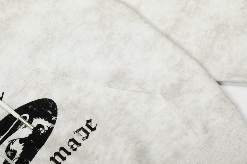 Close-up of hoodie side and pocket seam with faded white fabric and black print edge