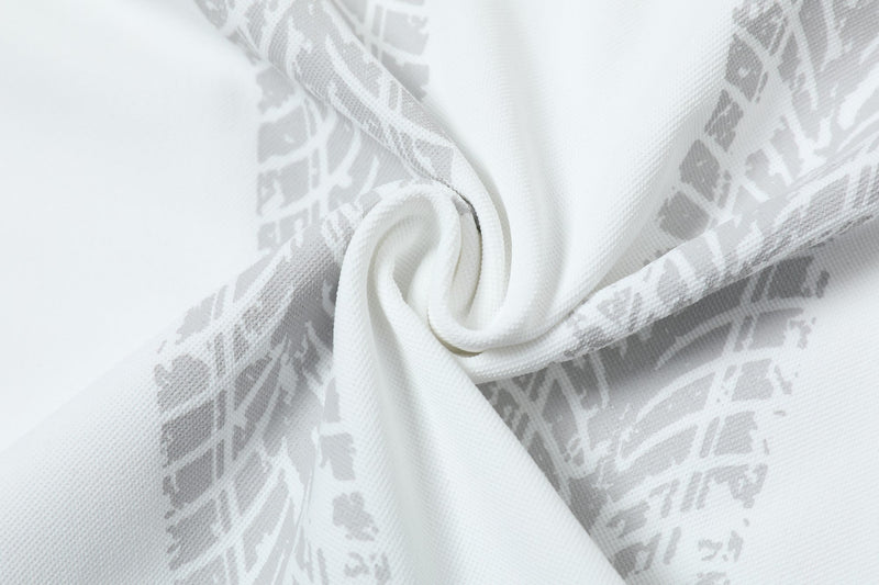 Close-up of white mesh fabric with subtle gray abstract soccer-inspired graphic pattern and folded texture