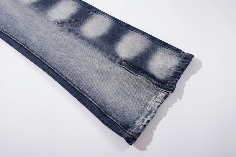 Close-up of lower leg and split hem on faded blue jeans