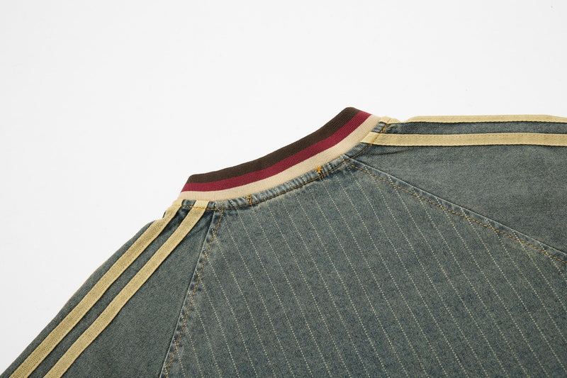 Close-up of a vintage denim sport tee with pinstripe fabric, striped ribbed collar, and tan shoulder trim