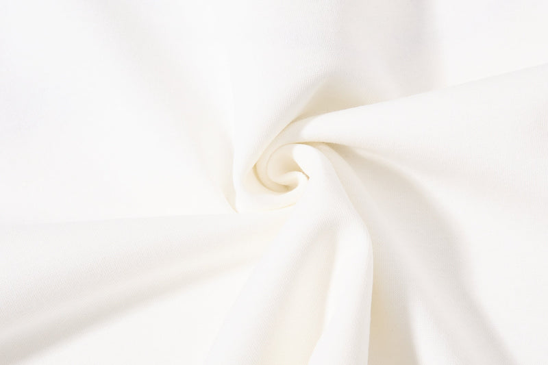 Cream polo shirt with subtle texture and folded fabric detail, shown in a clean minimalist studio view