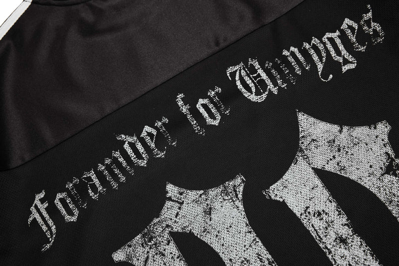 Close-up of a black mesh sport tee with distressed white gothic lettering and bold streetwear graphic print