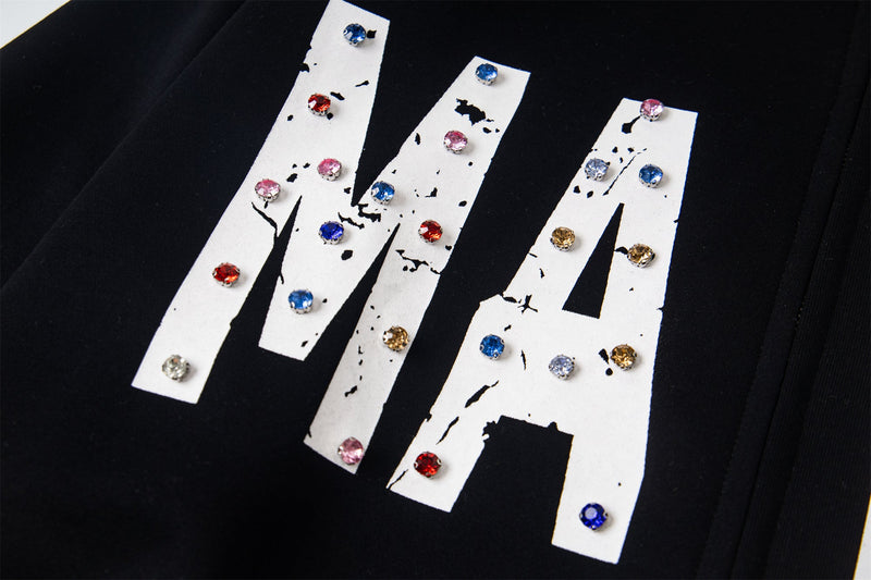 Close-up of black hoodie front lettering with multicolor rhinestones
